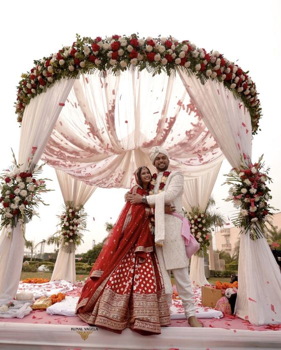 Bride and groom under a floral mandap